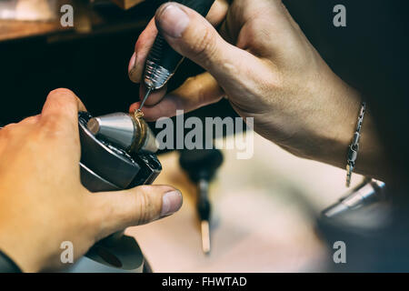 Juwelier arbeitet an einem Ring mit Präzisionswerkzeugen Stockfoto