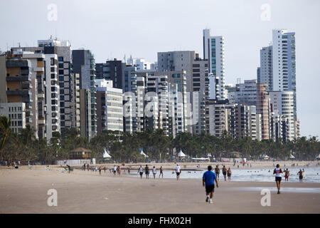 Badegäste am Strand von Boa Viagem mit Gebäuden im Hintergrund laufen Stockfoto