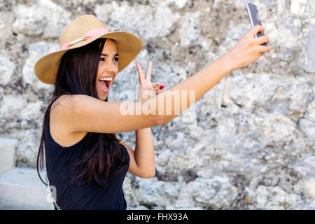 Schöne Brünette nehmen Selfie von sich selbst mit Freunden teilen Stockfoto