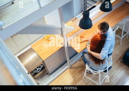 Paar umarmt und trinken Saft in der modernen Küche Stockfoto