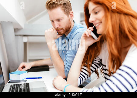 Kolleginnen und Kollegen arbeiten, studieren in weißen modernen Büro Stockfoto