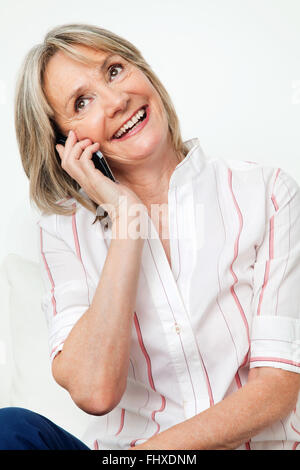 Glücklich lächelnde ältere Frau am Telefon sprechen Stockfoto