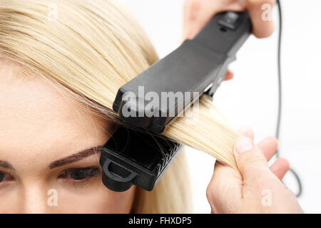 Eisen Barbiere, Haarglättung... Keratin Haarglättung... Friseur Frisur Modelle mit dem Glätteisen. Stockfoto