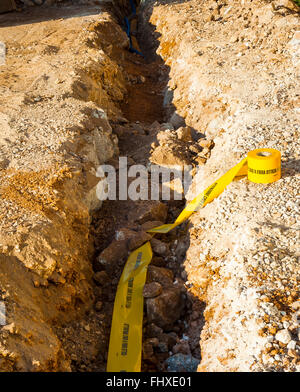 Platzierung der Warnung Band platziert in den Schützengräben, Kabelkanal aus optischen Fasern zu identifizieren. Stockfoto