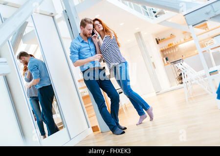 Lifestyle-Foto des Paares im Wohnzimmer umarmt und posiert Stockfoto