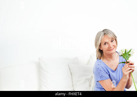 Beautiful senior Woman mit Bouquet von weißen Lilien Stockfoto