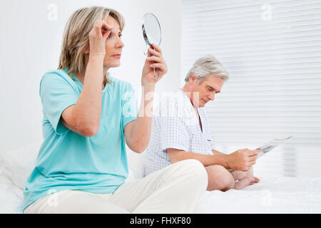 Älteren Ehepaar beschäftigt im Schlafzimmer vor dem Zubettgehen Stockfoto