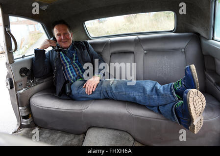 Mettmann, Deutschland. 26. Februar 2016. Oldtimer-Händler Michael Froehlich posiert mit der ehemaligen staatlichen Limousine des Schahs von Persien (1919-1980) in Mettmann, Deutschland, 26. Februar 2016. Der Cadillac von 1965 wurde speziell für den Schah Mohamed Reza Phlavi. Bis zu neun Personen könnten in das 6,5 Meter lange Fahrzeug passen. Im Jahr 2002 wurde der Wagen mittels einer Auktion in Genf in der Schweiz verkauft. Es kann nun von Michael Froehlich für 200.000 Euro gekauft werden. Foto: Horst Ossinger, Dpa/Alamy Live-Nachrichten Stockfoto