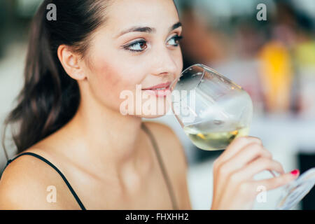 Schöne Frau, die Weinprobe beim Sitzen im restaurant Stockfoto