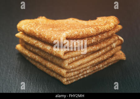 dünne Crepes oder Blinis gefaltet in Dreiecke auf Schiefer Stockfoto