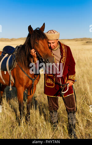 kasachische Mann in Trachten in der Steppe Reiten Stockfoto