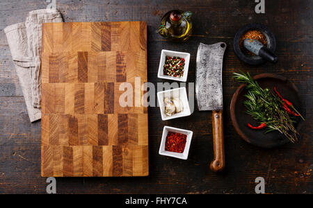 Schneidebrett Küche Gewürz Kräuter und Metzger Fleischerbeil auf dunklem Holz hacken Stockfoto