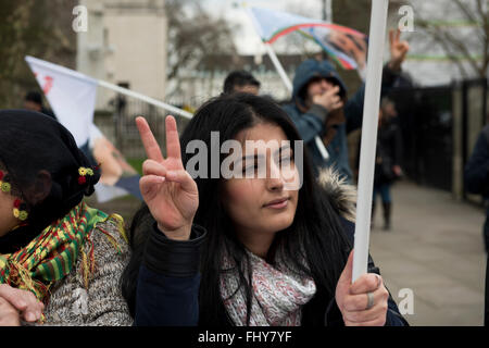 Eine junge kurdische Frau blinkt ein Friedenszeichen während der kurdischen Demonstration außerhalb der Downing Street, London, UK. Stockfoto