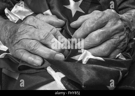 Alte Frau Hände halten eine amerikanische Flagge. Schwarz / weiß Bild. Selektiven Fokus. Stockfoto