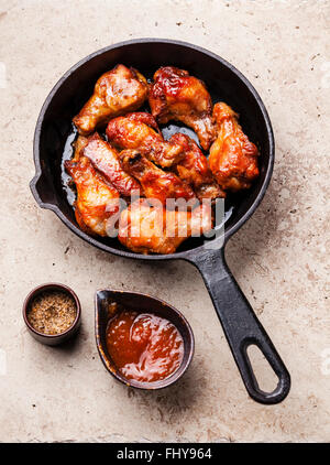 Fried Chicken Wings mit Sauce auf schwarze Pfanne Stockfoto