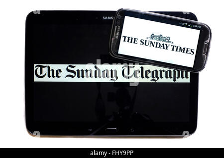 Die Logos der The Sunday Telegraph und The Sunday Times Zeitungen auf den Bildschirmen der ein Tablet und Smartphone angezeigt. Stockfoto