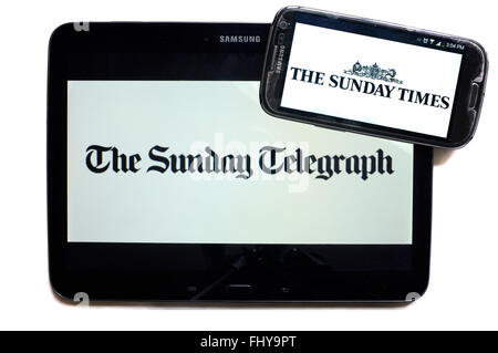 Die Logos der The Sunday Telegraph und The Sunday Times Zeitungen auf den Bildschirmen der ein Tablet und Smartphone angezeigt. Stockfoto