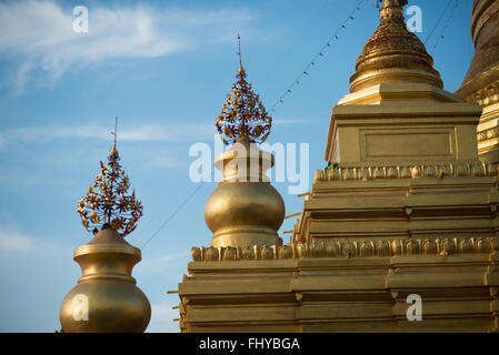 MANDALAY, Myanmar – die zentrale goldbedeckte Stupa der Kuthodaw-Pagode erhebt sich über dem Tempelkomplex. Dieses vergoldete Gebäude wurde 1857 während der Regierungszeit von König Mindon erbaut und dient als Mittelpunkt des Tempelgeländes, auf dem sich das größte Buch der Welt befindet. Die Stupa steht inmitten von 729 weißen Kyauksa-Gu mit Marmorplatten buddhistischer Schrift. Stockfoto