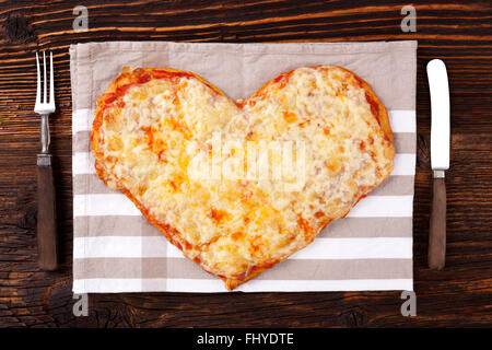 Leckere Pizza in Herzform auf Holztisch, Ansicht von oben. Kulinarischen Pizza essen. Ich liebe Pizza. Stockfoto