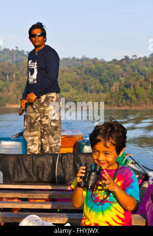 VAJRA GARRETT LOVELL mit dem Fernglas auf CHEOW EN See im KHAO SOK Nationalpark - THAILAND Stockfoto