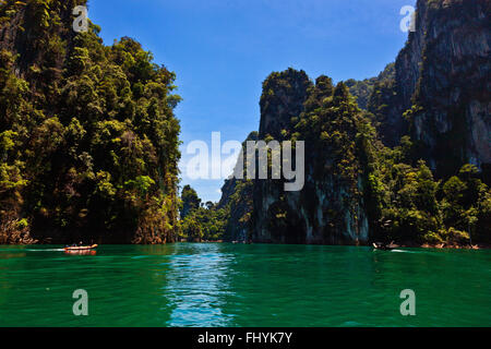 KARSTFORMATIONEN bedeckt mit tropischem Dschungel am CHEOW EN See im KHAO SOK Nationalpark - THAILAND Stockfoto