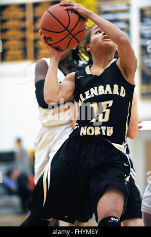 Spieler, die versuchen, nach einer Fahrt entlang der Basislinie und vorbei an einem Verteidiger bei einem High-School-Basketball-Spiel der Gäste. Stockfoto