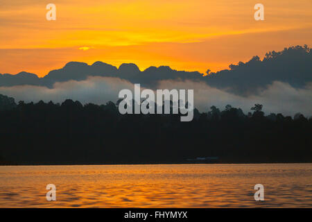 Sonnenuntergang am KLONG SAENG CHEOW EN See im KHAO SOK Nationalpark - THAILAND Stockfoto