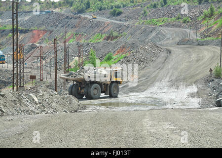 Muldenkipper und Zug liefert Eisenerz aus dem Tagebau Stockfoto