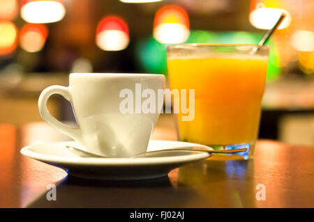Tasse Kaffee und ein Glas Orangensaft stehen auf einem Tisch in einem café Stockfoto