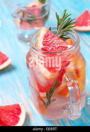 Limonade mit Grapefruit und Rosmarin in einem Einmachglas auf blauem Hintergrund Stockfoto