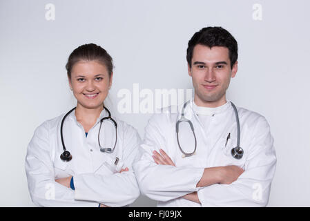 zwei junge Ärzte, männlich und weiblich in weißen Kitteln mit Stethoskop Stockfoto