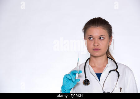 junge Ärztin mit Spritze in der Hand, mit blauen Handschuhen Stockfoto
