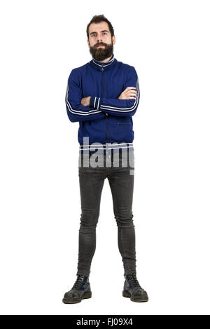 Sicher stolz bärtiger Mann in blauem Trainingsanzug Jacke und engen Jeans, Blick in die Kamera. Ganzkörper-Porträt isoliert auf weiss Stockfoto