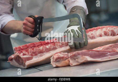 München, Deutschland. 24. Februar 2016. Ein Metzger zerstückelt ein Schwein auf dem Stand der Deutsche Fleischer Verband an die Internationale Handwerksmesse (IHM, beleuchtet. Internationale Messe für Handwerk) in München, Deutschland, 24. Februar 2016. Foto: SVEN HOPPE/Dpa/Alamy Live News Stockfoto