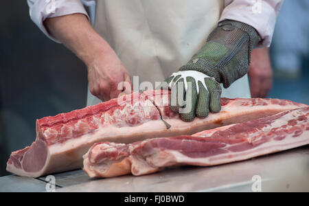 München, Deutschland. 24. Februar 2016. Ein Metzger zerstückelt ein Schwein auf dem Stand der Deutsche Fleischer Verband an die Internationale Handwerksmesse (IHM, beleuchtet. Internationale Messe für Handwerk) in München, Deutschland, 24. Februar 2016. Foto: SVEN HOPPE/Dpa/Alamy Live News Stockfoto