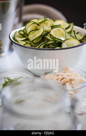Gurken in eine Schüssel geben, in Scheiben geschnitten, gebeizt werden. Stockfoto