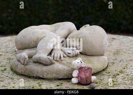 Eine Skulptur von einem schlafenden Baby gemacht aus Stein im Garten der Erinnerung für Unschuld Stockfoto