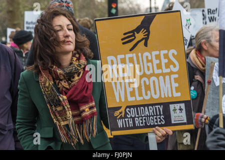 London, UK. 27. Februar 2016. Eine Frau trägt ein Plakat Aufnahme Flüchtlinge auf dem Marsch von Hyde Park Corner nach einer Kundgebung am Marble Arch am selben Tag als Proteste in anderen Städten in ganz Europa. Sie fordern Maßnahmen, um sicheres Geleit zu öffnen für alle Flüchtlinge und Asylsuchende, die Schutz in Europa suchen Möglichkeiten. Sie wollen ein Ende der Toten an den Grenzen und der Flüchtlinge in ihren Besitz zu halten und mit ihren Familien zusammengeführt werden dürfen. Peter Marshall, Alamy Live-Nachrichten Stockfoto