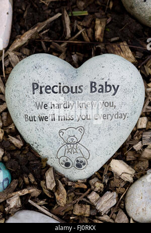 Hand bemalt Erinnerung Steinen auf einem Friedhof "Herzförmige kostbares Baby Stein" Stockfoto