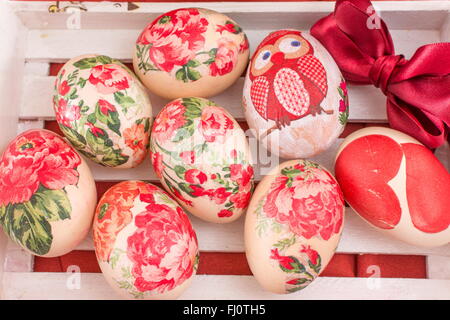 Hand bemalt und Serviettentechnik verziert Ostereier in einer Holzkiste Stockfoto