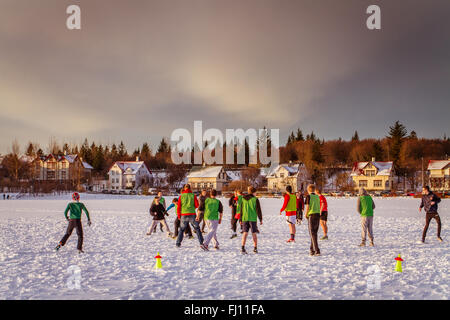 Menschen spielen Fußball auf dem tornin, der zugefrorene See in der Innenstadt von Reykjavik Stockfoto