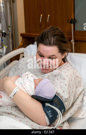 Fridley, Minnesota. Einheit-Krankenhaus. 31 Jahre alt, alleinerziehende Mutter Verklebung mit Bi-Rasse neugeborenes Mädchen im Krankenhaus. Stockfoto