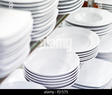 Stapel von sauberen weißen Platten auf Regal Stockfoto