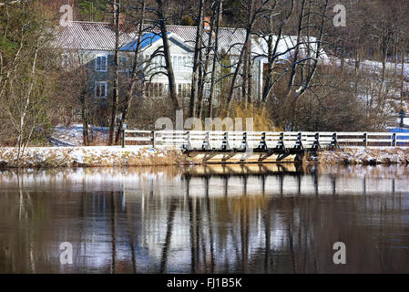 Eine alte Eisenbahnbrücke, heute als ein Gehweg und Fahrrad Weg genutzt. Es ist Winter und Schnee ist auf dem Boden. Der Fluss Morrumsan Stockfoto