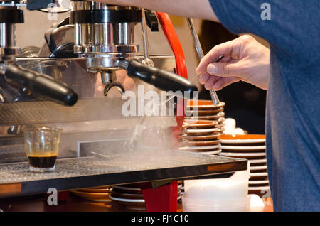 Ein Barista arbeiten bei einer Kaffeemaschine Stockfoto