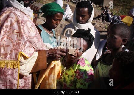 Priester schenkt Segen, die eine Frau während einer orthodoxen Zeremonie an Nakuta La'ab Kloster, in der Nähe von Lalibela, Äthiopien Stockfoto