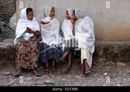 Eine Gruppe von orthodoxen äthiopischen Mädchen sitzen zusammen gesprochen in der Nähe der Kirche in Gonder, Äthiopien Stockfoto