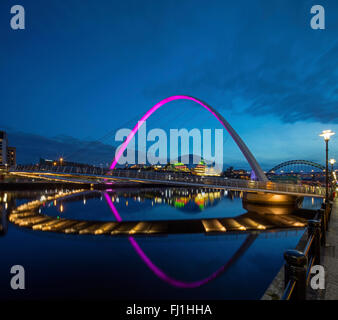 Nachtansicht der Gateshead Millennium Bridge spiegelt sich in den Fluss Tyne mit der Sage Gateshead & der Tyne Brücke im Hintergrund Stockfoto