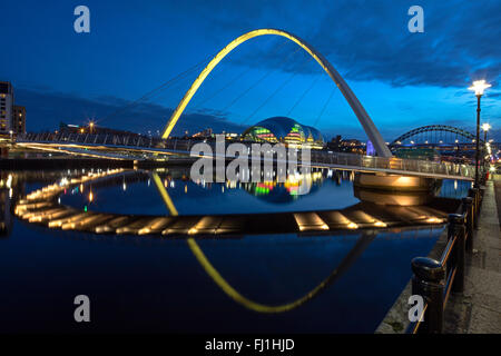 Nachtansicht der Gateshead Millennium Bridge spiegelt sich in den Fluss Tyne mit der Sage Gateshead & der Tyne Brücke im Hintergrund Stockfoto