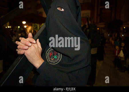 Inhaber- oder Nazareno hält ein Kreuz in Prozession der Karwoche, Spanien Stockfoto